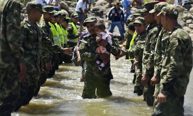 Archivo. Un niño es cargado para atravesar la frontera en el río Táchira, agosto 25, 2015. AFP PHOTO/ LUIS ACOSTA