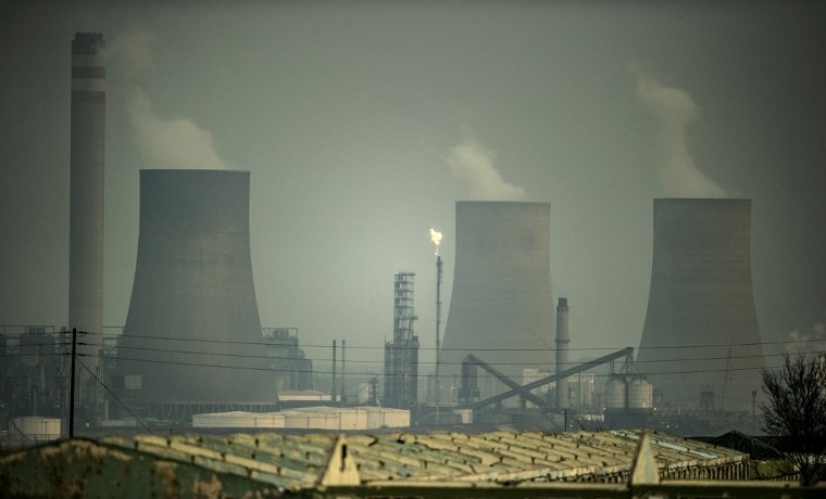 El humo se esparce de las torres de enfriamiento de la planta de combustible sintético en Secunda, una de las más grandes plantas de licuefacción de carbón en el mundo, que produce crudo sintético. AFP PHOTO / MUJAHID SAFODIEN