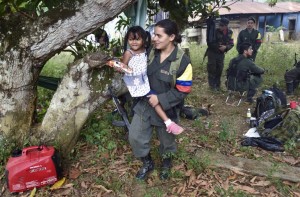 A member of the Revolutionary Armed Forces of Colombia (FARC) holds the daughter of a mate during a visit of their relatives, at a camp in the Colombian mountains on February 18, 2016. Many of these women are willing to be reunited with the children they gave birth and then left under protection of relatives or farmers, whenever the imminent peace agreement puts an end to the country's internal conflict. AFP PHOTO / LUIS ACOSTA / AFP / LUIS ACOSTA